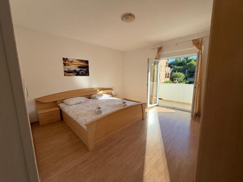 a bedroom with a bed and a large window at More Space, More Memories -Lana Rab Apartment in Rab