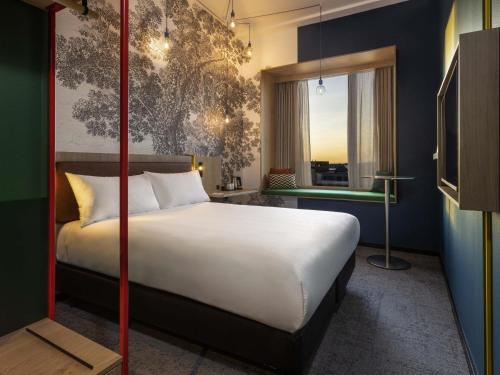 a bedroom with a large white bed and a window at ibis Styles Copenhagen Orestad in Copenhagen
