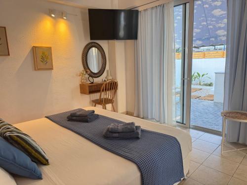 a bedroom with a large bed with towels on it at OLIA STUDIOS Olga studios in Faliraki