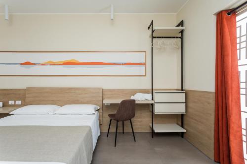 a bedroom with a bed and a desk and a chair at Vulcanica By Dimorra in Pozzuoli