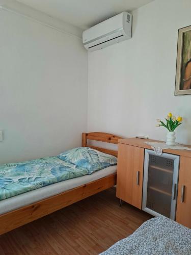 a bedroom with a bed and a desk with a television at Panoráma Vendégház in Sümeg
