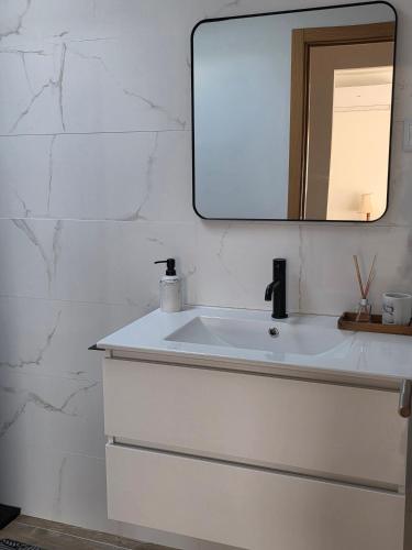 a bathroom with a white sink and a mirror at A Casinha - By Marketignite in Barreira