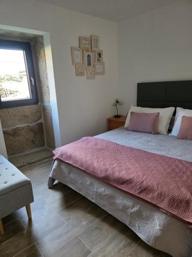 a bedroom with a large bed and a window at A Casinha - By Marketignite in Barreira