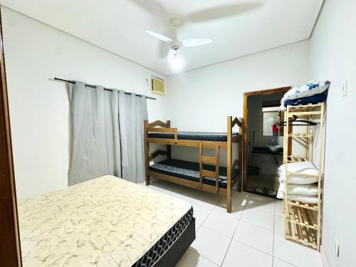 a room with a bed and bunk beds in it at Rancho Camiotto in Rubinéia