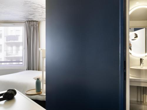 a hotel room with a bed and a window at ibis Paris Nation Davout in Paris