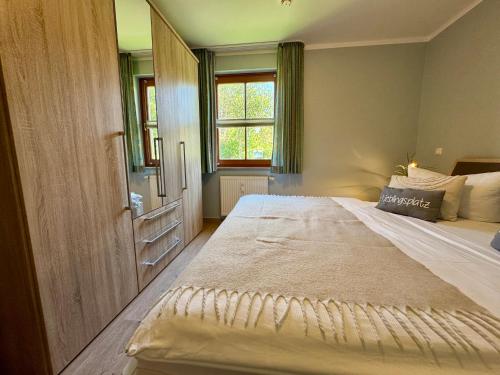 a bedroom with a large bed and a window at Oewern Diek App 03 in Wustrow