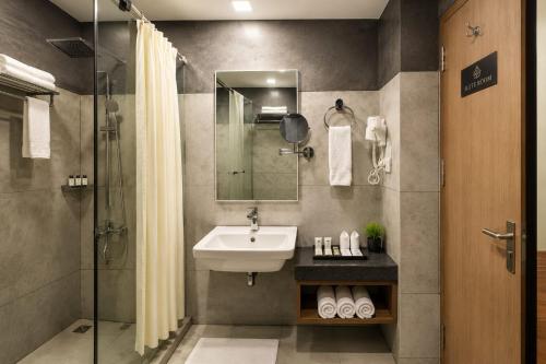 a bathroom with a sink and a shower at Hotel Sakthi in Kottayam