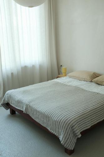 a bed in a white room with a window at Dadi House Martvili in Martvili