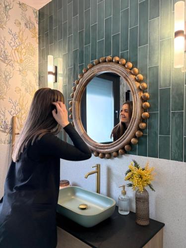 a woman standing in front of a sink in a bathroom at La Pionera in Mejorada