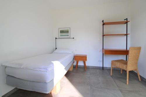 a bedroom with a bed and a desk and a chair at Bungalow Schifferberg Lodge in Ahrenshoop
