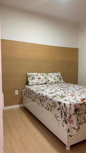 a bedroom with a bed with a wooden headboard at Aprt com ar varada conjugada,piscina in Aracaju