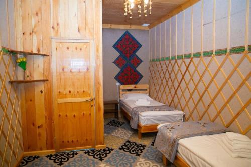 a small room with two beds in a room with at Ethno Naryn Guest House in Naryn