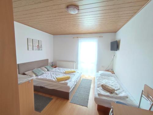 a small room with two beds and a window at Ubytovanie Erika in Vitanová