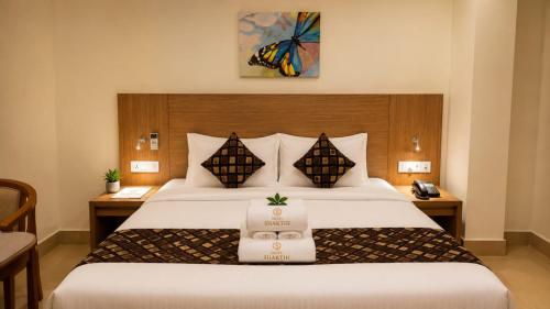 a hotel room with a bed with a sign on it at Hotel Sakthi in Kottayam
