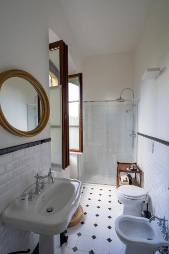 a white bathroom with a sink and a toilet at Il Giardino di Sofia in Arona