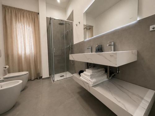 a bathroom with a sink and a shower and a toilet at Moon Apartments B in Soverato Marina