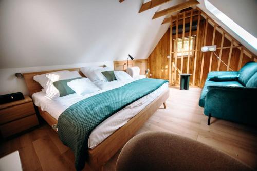 a bedroom with a large bed and a blue chair at Domek nad jeziorem z jacuzzi ROMANTICA in Wilamowo