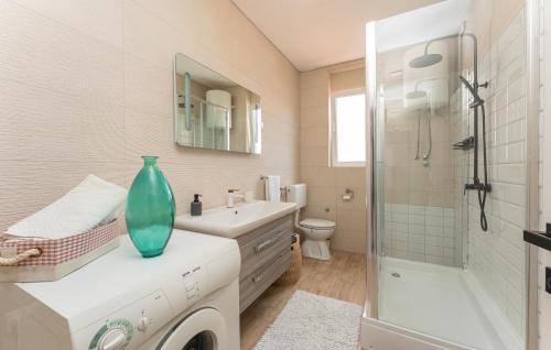 a bathroom with a sink and a glass vase on a counter at Olive Dreams in Biograd na Moru