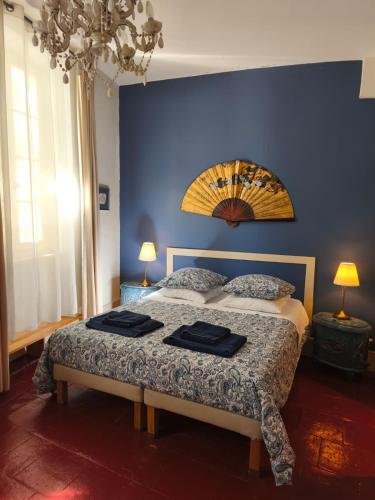 a bedroom with a large bed with a blue wall at Ombre Rose in Le Fousseret