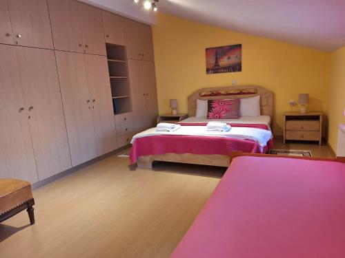 a bedroom with a large bed with pink sheets at Aegean View Seaside Apartment in Kavála
