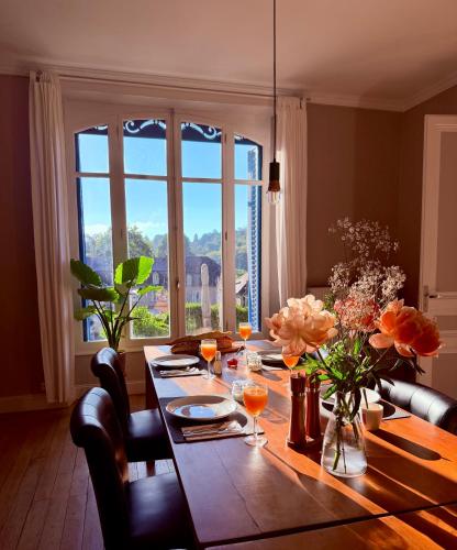 a dining room table with a view of a window at Ted et Breakfast in Corrèze