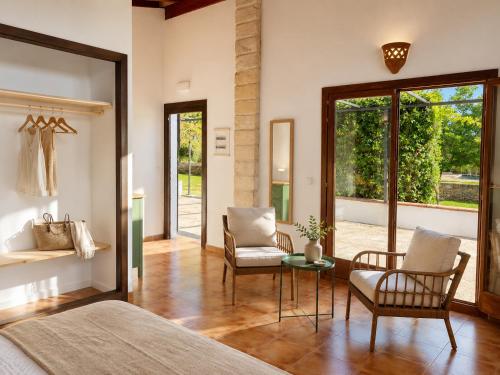 a bedroom with a bed and two chairs and a table at Finca Tramuntana in Palma de Mallorca