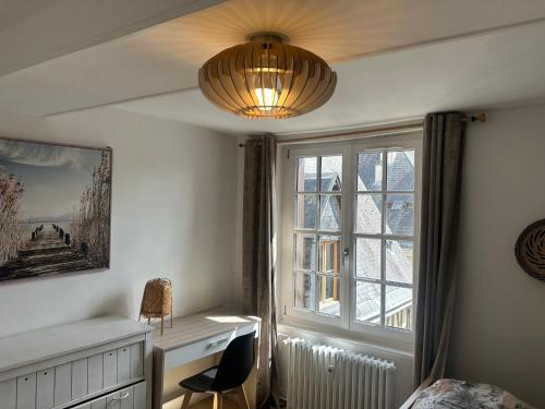 a bedroom with a desk and a window and a chandelier at Séjour agréable à Plaisir - 456 in Rouen