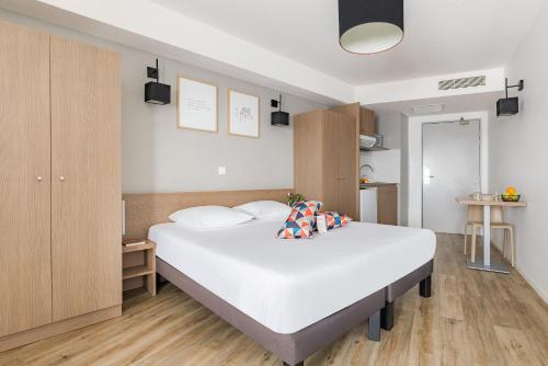 a bedroom with a large white bed in it at Appart'City Confort Mulhouse in Mulhouse