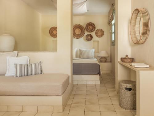 a small bedroom with a bed and a mirror at Verina Terra in Platis Gialos