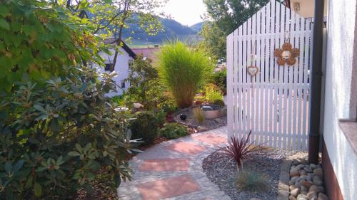 a garden with a white fence and a walkway at Ferienwohnung Himmelsbach in Schuttertal