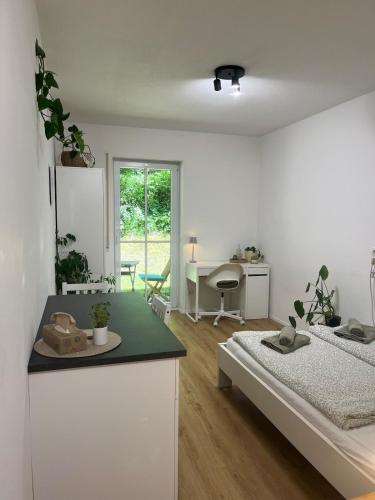 a room with a bed and a desk and a kitchen at Gemütliche Wohnung in Passau in Passau
