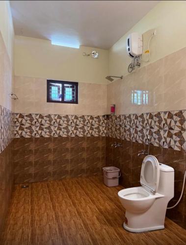 a bathroom with a toilet and a window at The Mystery palace in Varkala