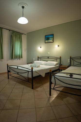 a room with two beds in a room with a light at Angela's studios in Elafonisos