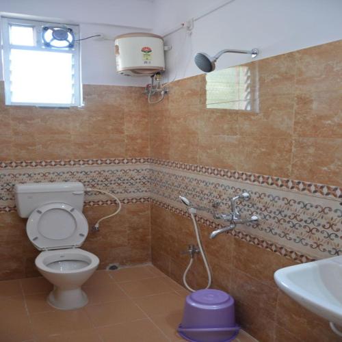 a bathroom with a toilet and a sink at Sri lucky grand lodge and function hall in Raigīr