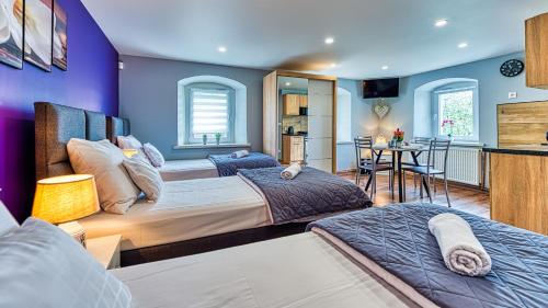 two beds in a room with purple walls at Maja Pokoje z Widokiem in Mirsk