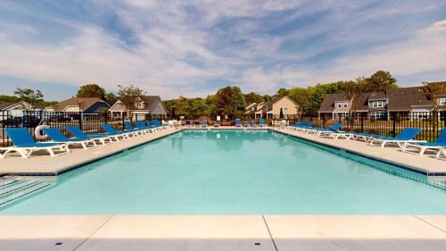 a large swimming pool with blue lounge chairs at Milos Haven house with community pool in Frankford