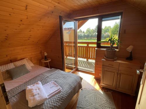 a bedroom with a bed and a window in a cabin at Kameleon2 in Dźwirzyno
