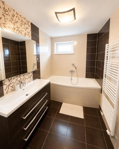 a bathroom with a tub and a sink at Apartmán Hollého in Žilina