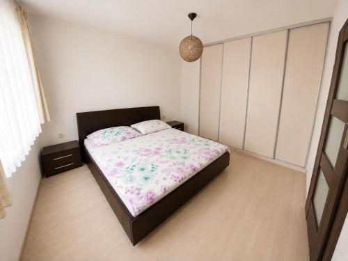 a bedroom with a bed with a floral bedspread at Apartmán Hollého in Žilina