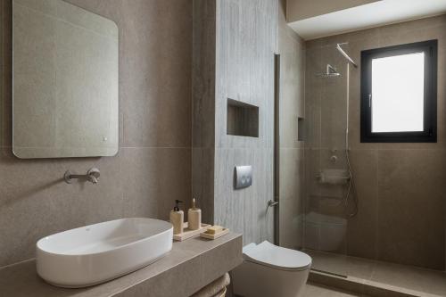a bathroom with a white sink and a toilet at Aeolia Residences in Nea Potidaea
