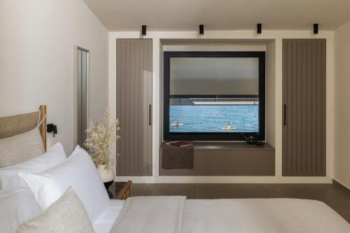 a bedroom with a window with a view of the ocean at Aeolia Residences in Nea Potidaea
