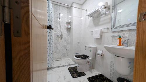 a bathroom with a shower and a toilet and a sink at AL MIDYAF Appart'Hôtel in El Jadida