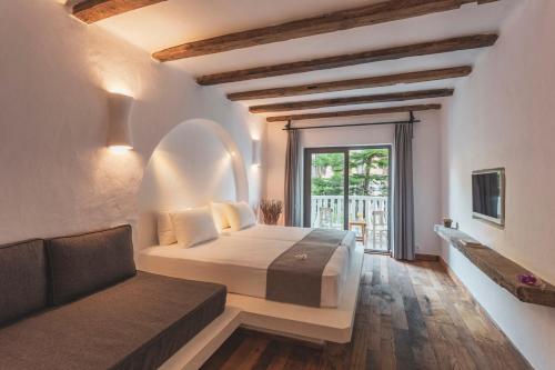 a bedroom with a bed and a couch and a window at Deluxe Rooms Pet Friendly in Fethiye