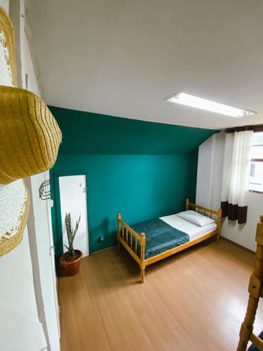 a bedroom with a bed and a blue wall at Garibaldi Hostel & Pub in Curitiba