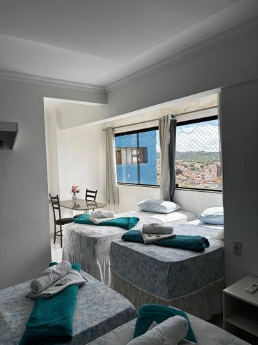 a room with three beds and a window at Lax Hotel - Acesso através de escadas - 4 andares - Sem elevador in Campina Grande