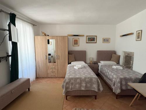a hotel room with two beds and a window at Old Town Mattarelli Studio in Kotor