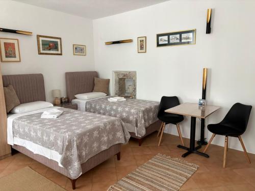a hotel room with two beds and a table at Old Town Mattarelli Studio in Kotor