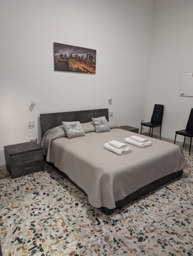 a bedroom with a large bed and two chairs at Koras 142 in Sennori