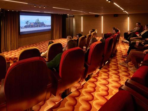 a group of people sitting in an auditorium watching a screen at Mama Shelter Dijon in Dijon