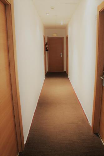 a hallway with a long corridor with a door at Hostal Restaurante EstaciÓN in Jaén